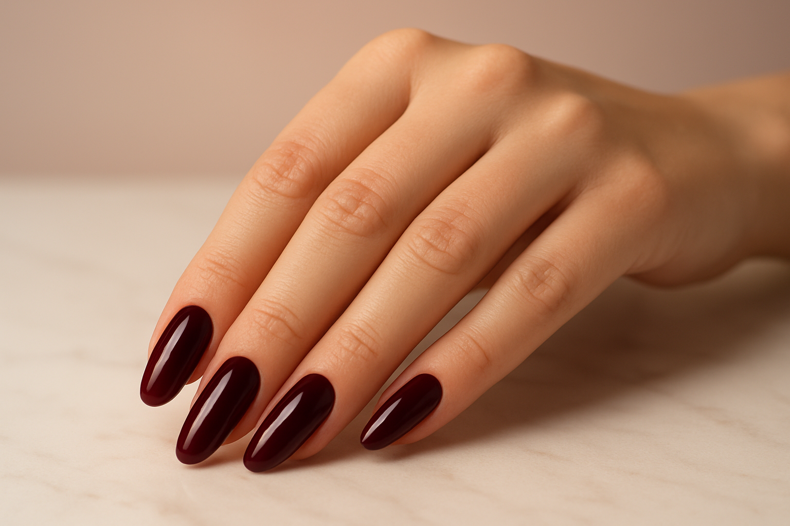 Close-up de unhas compridas pintadas com esmalte vinho escuro