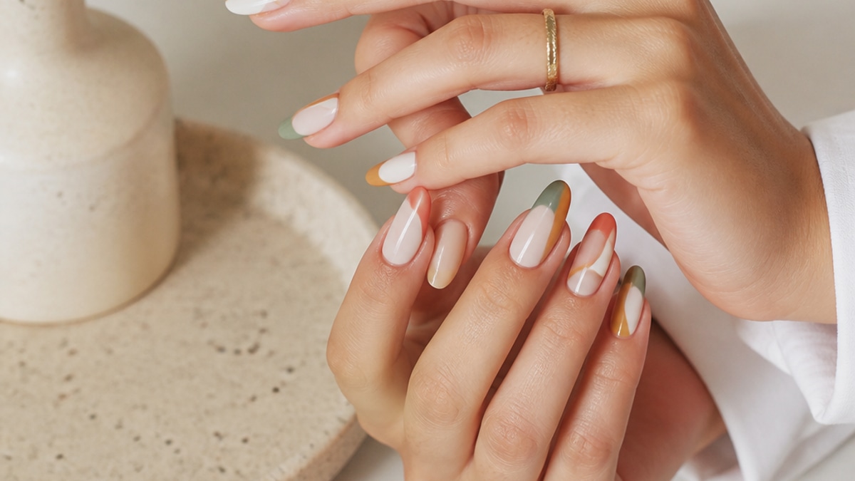 Mãos elegantes com unhas de gel coloridas em um ambiente bem iluminado, com fundo neutro.